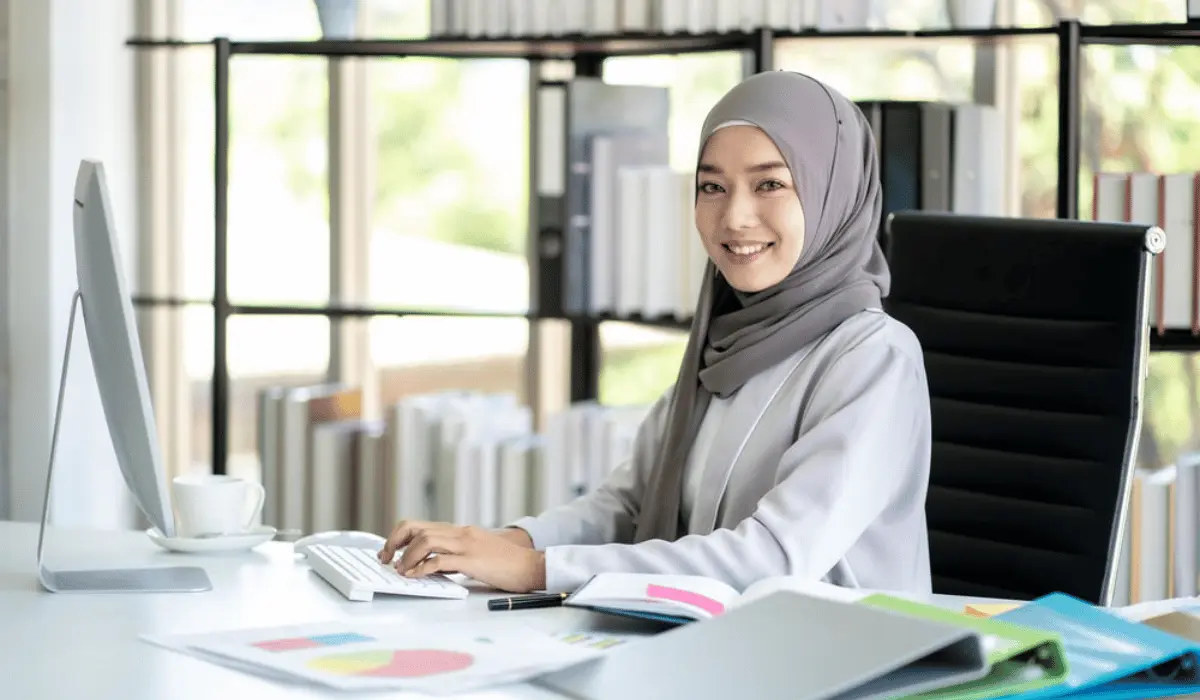 Malaysian employee smiling at camera while working on simple to use eLearning software
